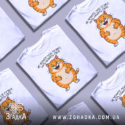 Футболка пузіко нажріть своє, біла футболка з принтом кота, ракурс спереду, фон світло-сірий, принт з усміхненим котом з оранжевими смужками, текст українською мовою.