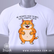 Футболка пузіко нажріть своє, біла футболка, зображена зверху, фон світло-сірий, принт з котом, що усміхається, текст українською мовою, на футболці є етикетка.