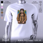 Футболка письменник Шевченко, біла, зображена на манекені, фон світло-сірий, принт з зображенням чоловіка в традиційному одязі з вусами та шапкою, на фоні жовто-блакитний прапор.