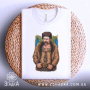 Футболка письменник Шевченко, біла, зображена на плетеній кошику, фон світло-сірий, принт з зображенням чоловіка в традиційному одязі, на фоні жовто-блакитний прапор.