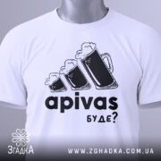 Футболка пивний гумор, біла, зображена зверху на плоскій поверхні, фон світло-сірий, принт з трьома пивними кухлями з пінкою та текстом 'apivas буде?', з зеленим ярликом.