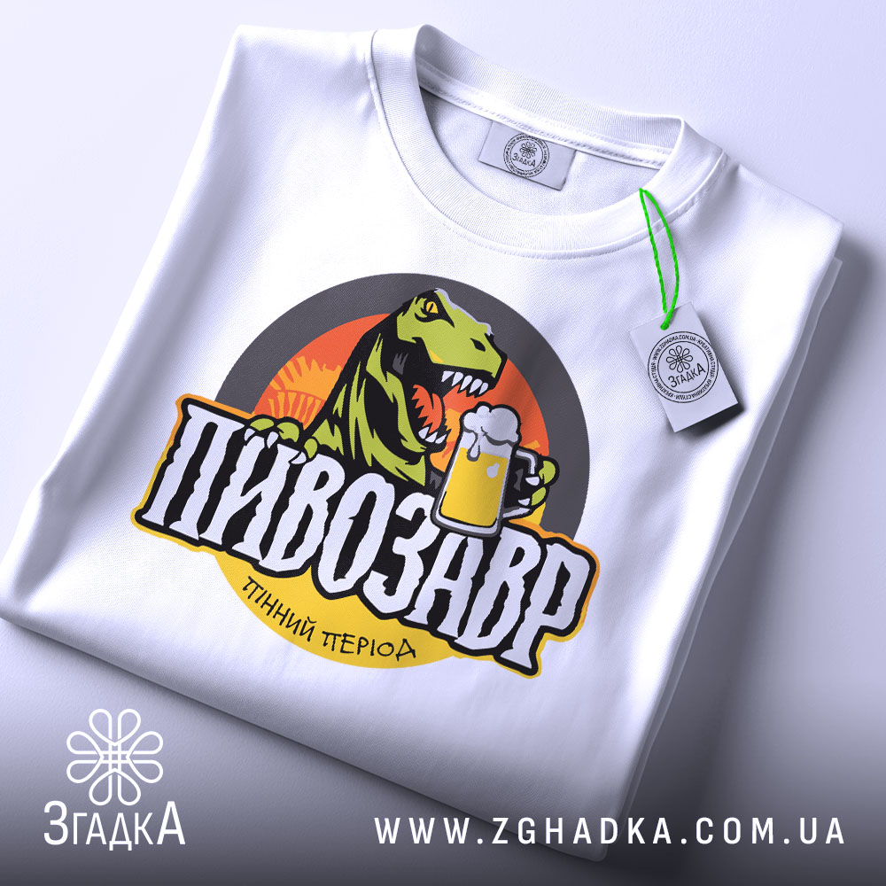 Футболка пивозавр пінний період, біла, зображена зверху, складена, фон світлий, принт з динозавром, що тримає пиво, кольори яскраві, на футболці є етикетка з зеленим шнурком.