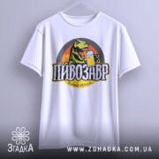 Футболка пивозавр пінний період, біла, зображена на вішалці, фон світлий, принт з динозавром, що тримає пиво, кольори яскраві, текст чорний з жовтими акцентами.