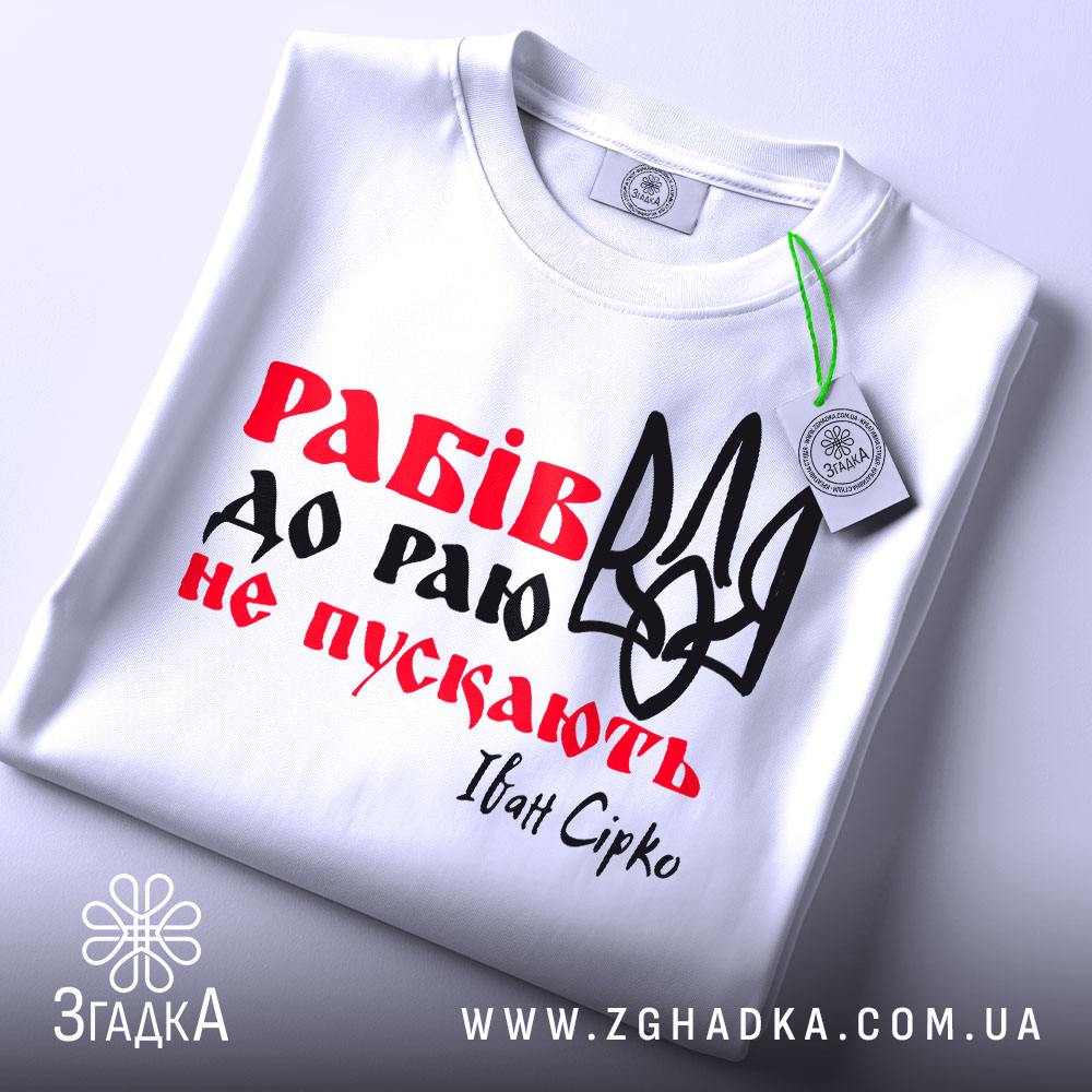 Футболка рабів не пускають, біла футболка складена в горизонтальному положенні, фон світлий, принт з червоним текстом "Рабів до раю не пускають" та чорним тризубом, на комірці видна етикетка.