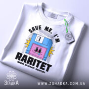 Футболка раритет живий артефакт, біла, зображена в складеному вигляді, фон світло-сірий, принт з веселим обличчям на дискеті та написом 'SAVE ME, I'M RARITET', прикріплена етикетка з зеленим шнурком.