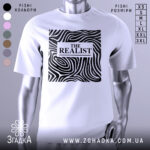 Футболка реаліст білого кольору, зображена на манекені з правого ракурсу, фон світло-сірий. Принт чорного кольору з абстрактними лініями та написом 'THE REALIST' у центрі.