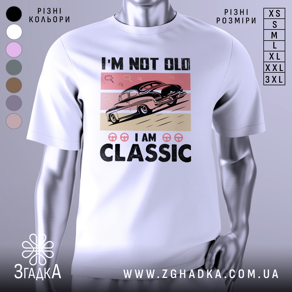 Futbolka Retro Avto Vybir Spravzhnikh Tsinyteliv 1 Футболка ретро авто білого кольору, зображена з фронтального ракурсу на манекені, фон світло-сірий, принт з автомобілем у стилі ретро на рожевому та бежевому фоні, текст "I'M NOT OLD I AM CLASSIC" великими чорними літерами.