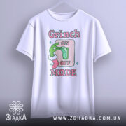 Футболка режим Грінча, біла, зображена на вішалці, фон градієнтний сірий, принт з зеленим рукою Грінча, що натискає на вимикач, текст 'ON OFF MODE' в рожевих і зелених кольорах.