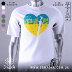 Футболка рідний дім, біла, зображена на манекені, фон світло-сірий, принт у формі серця з жовто-блакитними кольорами та написом 'РІДНИЙ ДІМ' у верхній частині, зображення меча в центрі.