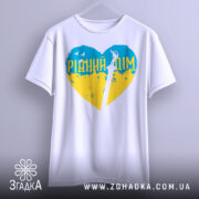 Футболка рідний дім, біла, підвішена на вішалці, фон світло-сірий, принт у формі серця з жовто-блакитними кольорами та написом 'РІДНИЙ ДІМ', зображення меча в центрі.