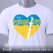 Футболка рідний дім, біла, складена на столі, фон світло-сірий, принт у формі серця з жовто-блакитними кольорами та написом 'РІДНИЙ ДІМ', з етикеткою на комірці.