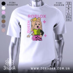 Футболка Roblox королева, біла, зображена на манекені, фон нейтральний, принт з персонажем у короні, кольорові деталі на одязі, текст 'ROBLOX QUEEN' у рожевому кольорі.