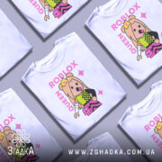 Футболка Roblox королева, біла, зображена на манекені, фон нейтральний, принт з персонажем у короні, кольорові деталі на одязі, текст 'ROBLOX QUEEN' у рожевому кольорі.