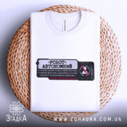 Футболка робот автономний, біла, складена на плетеній основі, фон нейтральний, принт чорного кольору з червоними елементами, текст на українській мові.