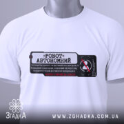 Футболка робот автономний, біла, складена на столі, фон світлий, принт чорного кольору з червоними елементами, текст на українській мові, на футболці є етикетка.