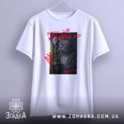 Футболка роби що хочеш, біла, зображена з фронтального ракурсу, фон світло-сірий, принт з котом у свитері з тризубом, котяча фігура з сигаретою, текст червоним кольором.