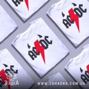 Футболка рок енергія, біла, зображена на манекені, фон світло-сірий, принт з червоним блискавкою та чорними літерами 'AC/DC'.