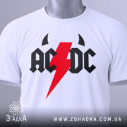 Футболка рок енергія, біла, складена на поверхні, фон світло-сірий, принт з червоним блискавкою та чорними літерами 'AC/DC', з етикеткою на зеленому шнурку.