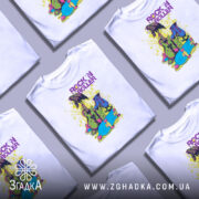 Футболка рок і арт білого кольору, зображена з фронтального ракурсу на манекені, фон світло-сірий, принт містить яскраві елементи: гітару, роликові ковзани та напис 'ROCK 'N ROLLER' у фіолетовому кольорі.