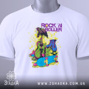 Футболка рок і арт білого кольору, складена на поверхні, зображена зверху, фон світло-сірий, принт яскравий з елементами: гітара, роликові ковзани та напис 'ROCK 'N ROLLER' у фіолетовому кольорі, на футболці є етикетка.