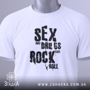 Футболка рок стиль, біла, зображена зверху, на столі, фон світло-сірий, принт чорний з написом 'SEX and DRUGS and ROCK n' ROLL', з етикеткою на зеленій стрічці.