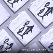 Футболка розмір має значення, біла, зображена на манекені з блискучого металу, фон нейтральний, принт з рибами та написами "РОЗМІР", "МАС" і "ЗНАЧЕННЯ" у чорному кольорі.