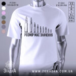 Футболка розмір має значення, біла, зображена на манекені, фон нейтральний, принт з дев'яти патронів різного розміру, текст чорного кольору під принтом.