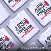 Футболка руки з дупи, біла, зображена на манекені, фон світло-сірий, принт чорного та червоного кольору з текстом "ОЧІ БОЯТЬСЯ РУКИ З ДУПИ АЛЕ Я НЕ ЗДАЮСЯ" та зображенням ключа і пластиру.