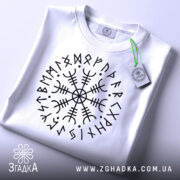 Футболка руни вікінгів, біла, складена на поверхні, з видимим етикеткою, фон світлий, принт з чорними рунами у формі кола.