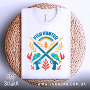 Футболка рибалка мисливець, біла, зображена зверху на плетеній основі, фон білий, принт з рибами, гарпунами та рослинами, яскраві кольори.