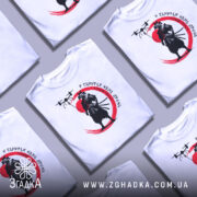 Футболка самурай без дрона, біла, зображена на манекені, фон нейтральний, принт з чорним самураєм на червоному колі та дронами над ним.