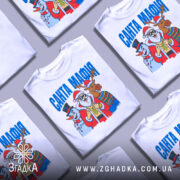 Футболка Санта Мафія білого кольору, зображена на манекені, ракурс спереду, фон світло-сірий, принт з Сантою, сніговиком і оленем, яскраві кольори, текст "САНТА МАФІЯ" вгорі.