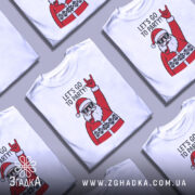 Футболка Санта рок, біла, зображена на манекені, фон світло-сірий, принт з веселим Сантою в окулярах, який піднімає руку в жесті рокера, текст "LET'S GO TO PARTY!" над принтом.