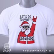 Футболка Санта рок, біла, складена на столі, фон світло-сірий, принт з Сантою в окулярах, який піднімає руку в жесті рокера, текст "LET'S GO TO PARTY!" над принтом, на футболці є етикетка.