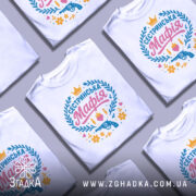 Футболка сестринська мафія білого кольору, зображена на манекені з бокового ракурсу, фон світло-сірий, принт містить кольорові елементи: напис 'Сестринська Мафія', пістолет, кулі, квіти та сердечка.