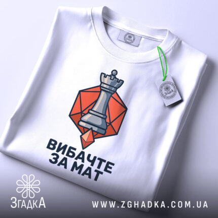 Футболка шаховий король, біла, зображена зверху, фон світлий, принт з шаховою фігурою короля на оранжевому фоні, з етикеткою, що звисає.