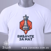 Футболка шаховий король, біла, зображена зверху, фон світлий, принт з шаховою фігурою короля на оранжевому фоні, з етикеткою, що звисає.