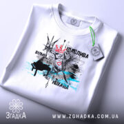 Футболка щаслива вільна, білого кольору, складена на поверхні з нейтральним фоном. Принт зображує птаха з короною, серцем та абстрактними елементами в чорному і блакитному кольорах, з етикеткою на рукаві.