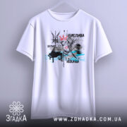 Футболка щаслива вільна, білого кольору, підвішена на вішалці, фон світло-сірий. Принт включає малюнок птаха з короною, серцем та чорними і блакитними елементами.