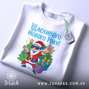 Футболка щасливого нового року, білого кольору, з ракурсу зверху, на фоні світло-сірого градієнту, принт з дідом Морозом у сонцезахисних окулярах, який радісно жестикулює, з ялинкою та подарунками.