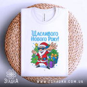 Футболка щасливого нового року, білого кольору, з ракурсу зверху, на фоні плетеного кошика, принт з дідом Морозом у сонцезахисних окулярах, який радісно жестикулює, з ялинкою та подарунками.