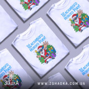 Футболка щасливого нового року, білого кольору, з ракурсу спереду, на фоні світло-сірого градієнту, принт з веселим дідом Морозом у сонцезахисних окулярах, який стоїть біля ялинки з подарунками.