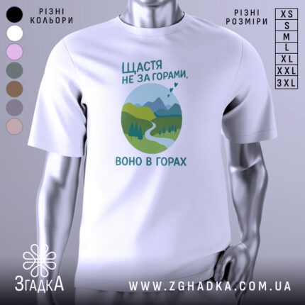 Футболка щастя в горах, біла, зображена на манекені, фон світло-сірий, принт з горами, річкою та деревами в зелених відтінках, текст українською мовою.
