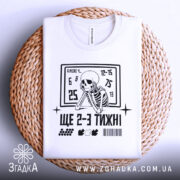 Футболка ще 2-3 тижні, біла, складена на плетеній основі, фон світло-сірий, принт з чорним скелетом, що сидить, та текстом.