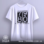 Футболка ще той олдовий. Біла футболка з коротким рукавом, підвішена на вішалці, зображена з фронтального ракурсу. Принт чорного кольору з написом 'OLDOMETER 79 80' та фразою 'Я ще той олдовий!' розташований по центру.