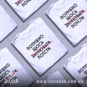 Футболка білого кольору, зображена з фронтального ракурсу на манекені, фон світло-сірий, принт чорного кольору з текстом "ПОТРІБНО ЩОСЬ ЗМІНЮВАТИ ПОЇСТИ".