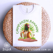 Футболка Shimpanzini Bananini білого кольору, зображена зверху на плетеній основі, фон світло-сірий, принт з мавпою на банані оточений зеленими рослинами.