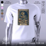 Футболка скелет читає, біла, зображена на манекені, фон світло-сірий, принт з скелетом, що читає книгу під місяцем, оточений книгами та свічкою.