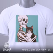 Футболка скелет кіт білого кольору, зображена зверху, на ній видно етикетку, фон світло-сірий, принт зображає скелет, що обіймає чорного кота з великими очима.