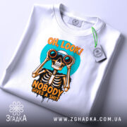 Футболка скелет з написом, біла, зображена на плоскій поверхні, фон світло-сірий, принт з черепом, що тримає бінокль, кольори принта яскраві: оранжевий, чорний, блакитний, з етикеткою.